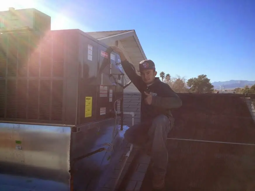 HVAC technician performing Air Duct Cleaning on a rooftop unit in Kimberly